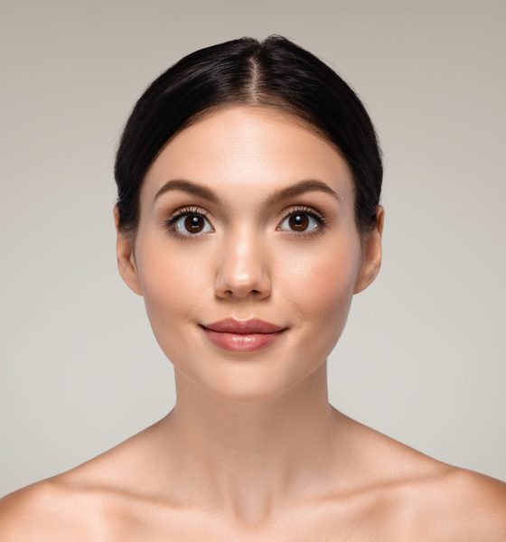 Smiling millennial european woman with perfect skin enjoy result of routine procedures, isolated on gray studio background, close up. Beauty care, nude, basic makeup, spa treatment